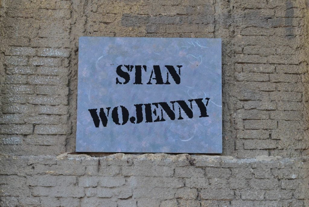 kamienna tablica z napisem stan wojenny wisząca na murze - odszkodowanie i zadośćuczynienie za internowanie