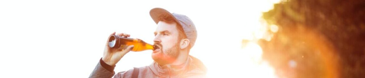 Mężczyzna pijący piwo przed jazdą samochodem - Jakie sa okolicznosci lagodzace kare za jazde pod wplywem alkoholu